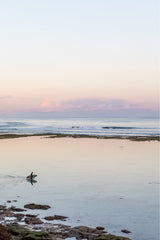 photograph by sheila man of a surfer in the ocean at sunset time