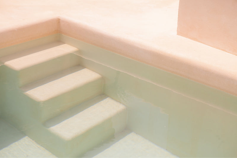 slight pink coloured photograph of minimalistic pool stairs in a bali villa